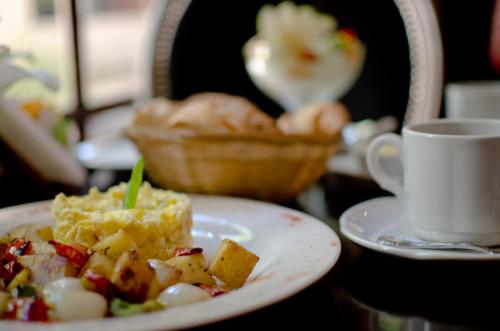 a table with a plate of food and a cup of coffee at Miravida Soho Hotel & Wine Bar in Buenos Aires