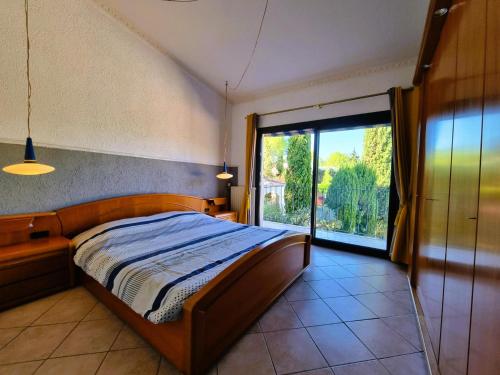 une chambre avec un lit et une grande fenêtre dans l'établissement Soleil OC, à Pouzols-Minervois