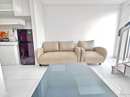 a living room with a couch and a kitchen at Cozy 1BR Casa De Parco Apt with Pool & Gym in Samporo