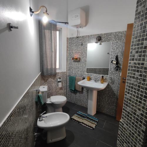 a bathroom with two toilets and a sink and a mirror at Casa Papaya19 in Sal Rei