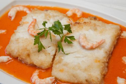 a plate of shrimp soup with shrimp and parsley on top at Hotel Las Murallas in Avila