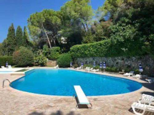 une grande piscine bleue avec des chaises et des arbres dans l'établissement Luxurious luxury apartment in Cannes -, à Cannes