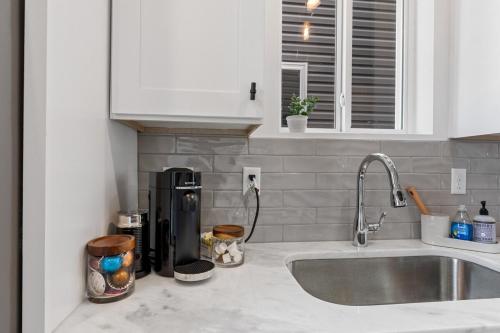 Una encimera de cocina con una cafetera y un fregadero. en Boudin House Luxury Amenities Prime Location WiFi, en Lafayette