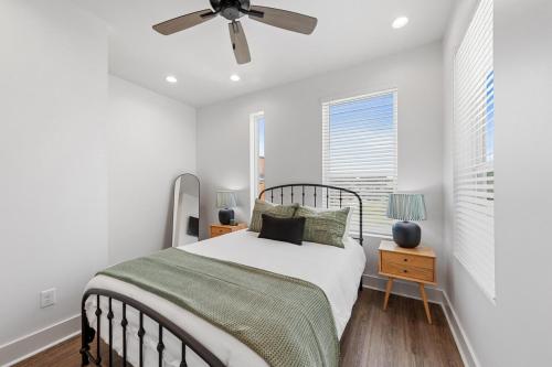 Un dormitorio blanco con una cama y un ventilador de techo. en Boudin House Luxury Amenities Prime Location WiFi, en Lafayette