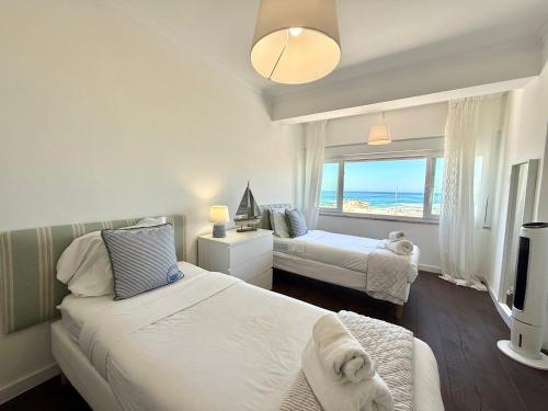 コスタ・ダ・カパリカにあるThe Luxe View Spotのベッドが2つあり、海が見えるベッドルーム