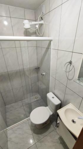 a white bathroom with a toilet and a sink at Geminado 2 in Santa Cruz do Sul