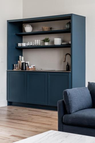 a living room with a blue cabinet and a couch at The Skowhegan By Kasa in Skowhegan