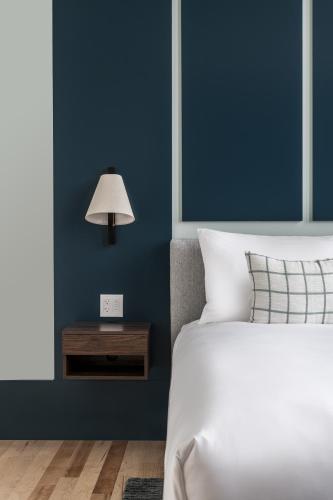 a bedroom with a bed and a nightstand with a lamp at The Skowhegan By Kasa in Skowhegan