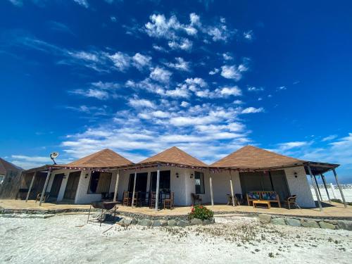a house with a roof on the beach at Casona TikiTano Lodge 12 personas in Totoralillo