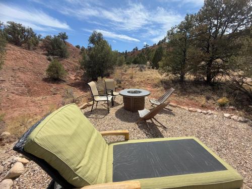a patio with a table and chairs and a picnic table at Bryce Glamp And Camp in Cannonville