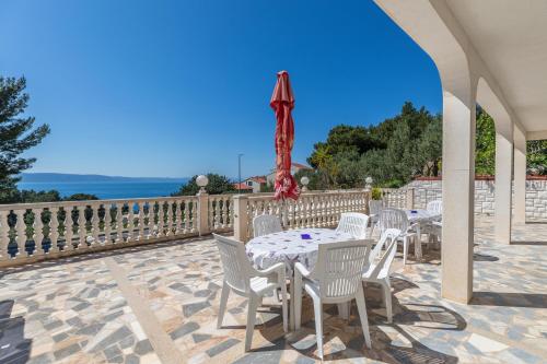 a patio with a table and chairs and an umbrella at Apartments and rooms with parking space Podgora, Makarska - 23916 in Podgora