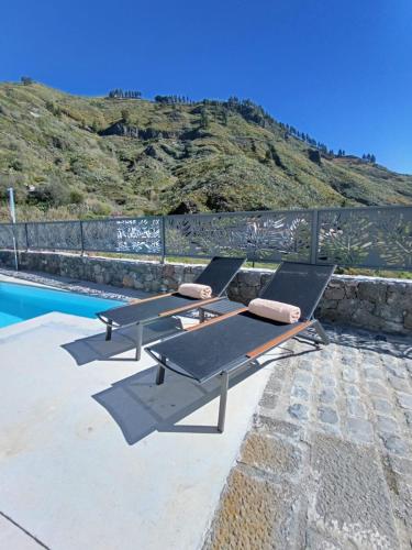 a table and two chairs next to a swimming pool at Natura Luxury in Las Lagunetas