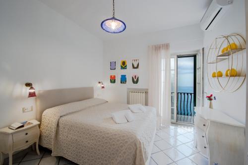 une chambre blanche avec un lit et une salle de bain dans l'établissement Villa Il Lupo Felice, à Ravello