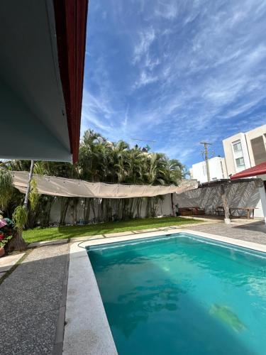 a swimming pool in front of a house at Casa Madera in Acapulco