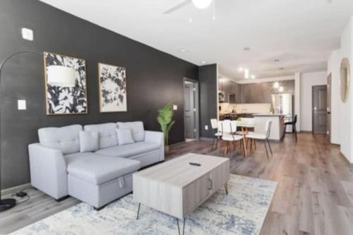 a living room with a white couch and a table at Luxurious King 2BR Suite in North Raleigh! in Raleigh