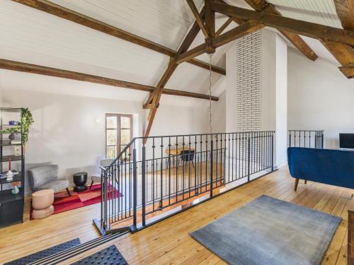 an attic living room with a blue couch and wooden floors at Grande maison de campagne rénovée avec parking et espace détente - FR-1-306-1303 in Malville