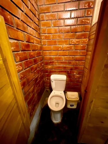 a small bathroom with a toilet in a brick wall at Casa Colpa Tiki in Chincha