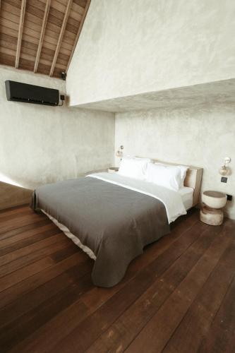 1 dormitorio con 1 cama grande y TV en la pared en The Iggy Hotel Seseh Loft 8, en Cemagi
