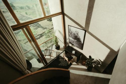 una vista aérea de una sala de estar con una gran ventana en The Iggy Hotel Seseh Loft 8, en Cemagi