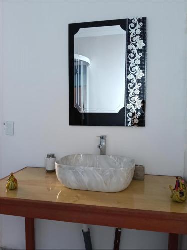 a large white sink on a wooden counter with a mirror at Titicaca EcoLux in Puno