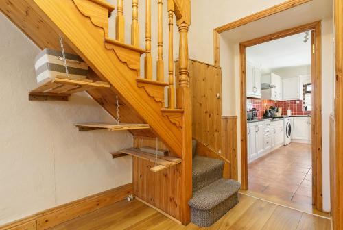 a wooden staircase in a home with a kitchen at Union Place in Sligo