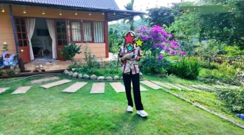 a woman standing in front of a house at Cozy Hill Retreat in Gia Nghĩa