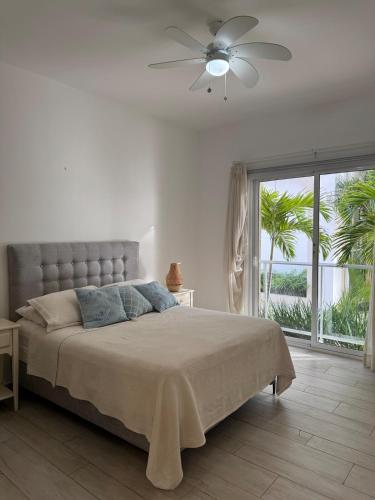 プンタ・カナにあるRelax in Cana Pearl, Punta Canaの白いベッドルーム(ベッド1台、天井ファン付)