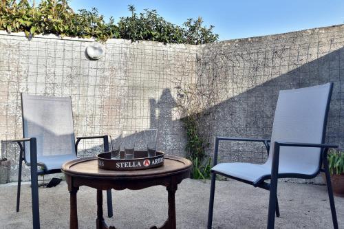 3 chaises et une table avec un bol sur le dessus dans l'établissement La Saudrais - Parking - Jardin, à Dinard