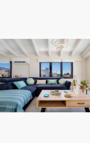 a living room with a blue couch and a table at Angela Home, 5Street, Perivolia in Perivólia