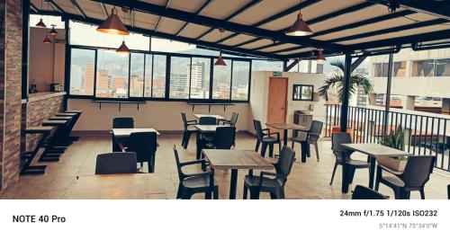a restaurant with tables and chairs and windows at Medellin Continental Hotel in Medellín