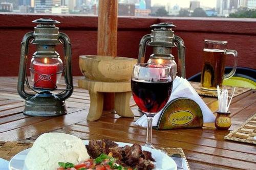 a glass of wine sitting on a table with food at Khweza Bed and Breakfast in Nairobi