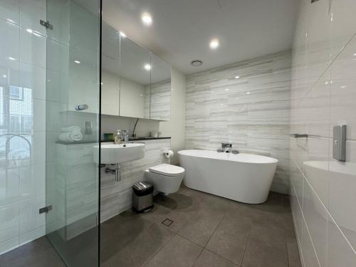 a bathroom with a tub and a toilet and a sink at Entire Apartment in Zetland in Sydney