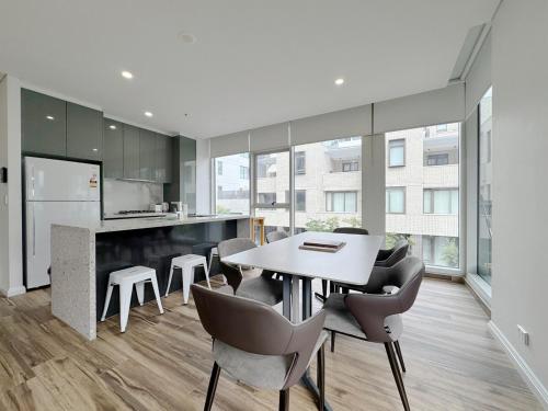 a kitchen and dining room with a table and chairs at Entire Apartment in Zetland in Sydney