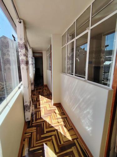 a hallway with a floor with a view of a building at Hostal San Antonio Inn in Puno