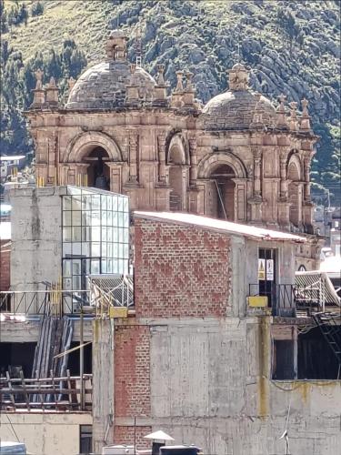 an old brick building in front of a mountain at Hostal San Antonio Inn in Puno