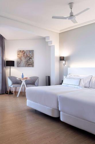 a hotel room with two beds and a table at Meliá Isla Canela in Isla Canela