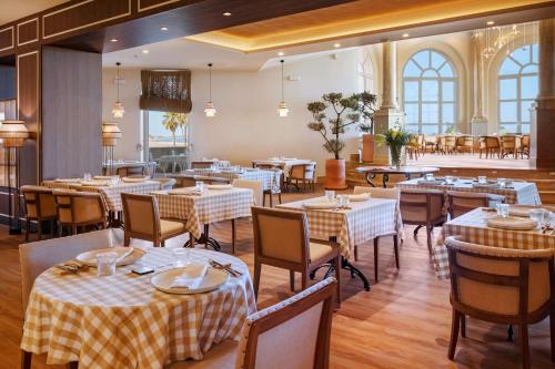 a restaurant with tables and chairs in a room at Meliá Isla Canela in Isla Canela