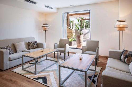a living room with two couches and a table at Meliá Isla Canela in Isla Canela