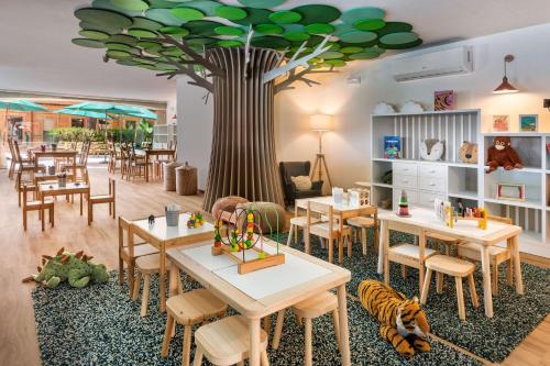 a restaurant with tables and a tree on the ceiling at Meliá Isla Canela in Isla Canela