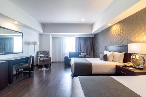 a hotel room with two beds and a desk at Ejecutivo Express Guadalajara Providencia - Av México in Guadalajara