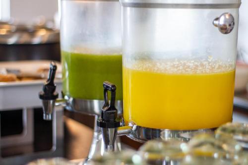 a blender filled with orange liquid sitting on a counter at Ejecutivo Express Guadalajara Providencia - Av México in Guadalajara