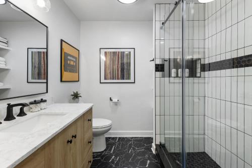 a bathroom with a toilet and a glass shower at Nashville Oasis Walk to Broadway with POOL, Parking, Gym and Patio in Nashville