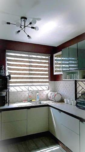 a kitchen with a sink and a window at JResidences - 5 Bedrooms Cozy Home in Bacolod