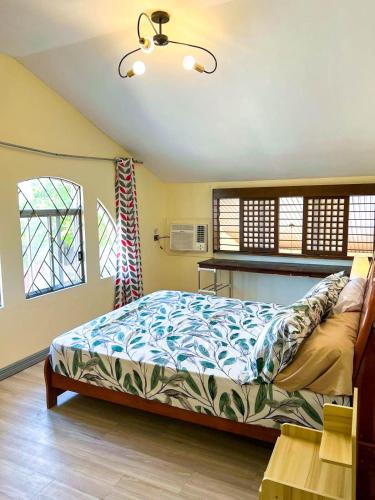 a bedroom with a bed and two windows at JResidences - 5 Bedrooms Cozy Home in Bacolod