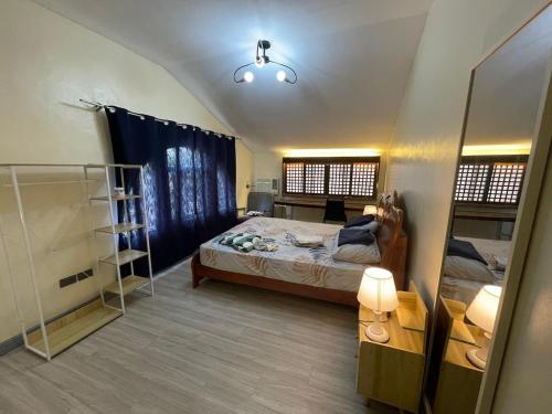 a small room with a bed and a mirror at JResidences - 5 Bedrooms Cozy Home in Bacolod