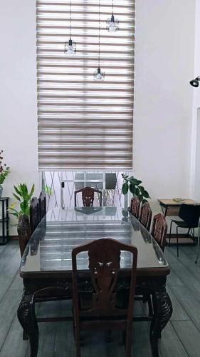 a table and chairs in a room with a window at JResidences - 5 Bedrooms Cozy Home in Bacolod