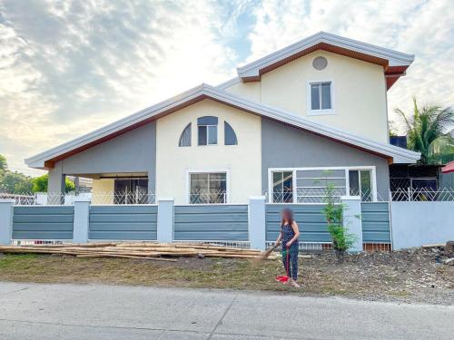 a young girl standing in front of a house at JResidences - 5 Bedrooms Cozy Home in Bacolod