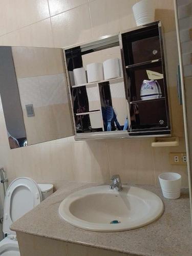 a bathroom with a sink and a toilet and a mirror at JResidences - 5 Bedrooms Cozy Home in Bacolod