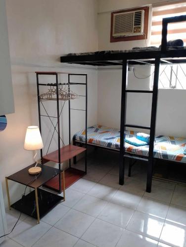 a room with two bunk beds with a lamp and a table at JResidences - 5 Bedrooms Cozy Home in Bacolod