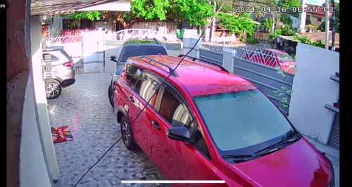 a red car parked on the side of a street at JResidences - 5 Bedrooms Cozy Home in Bacolod